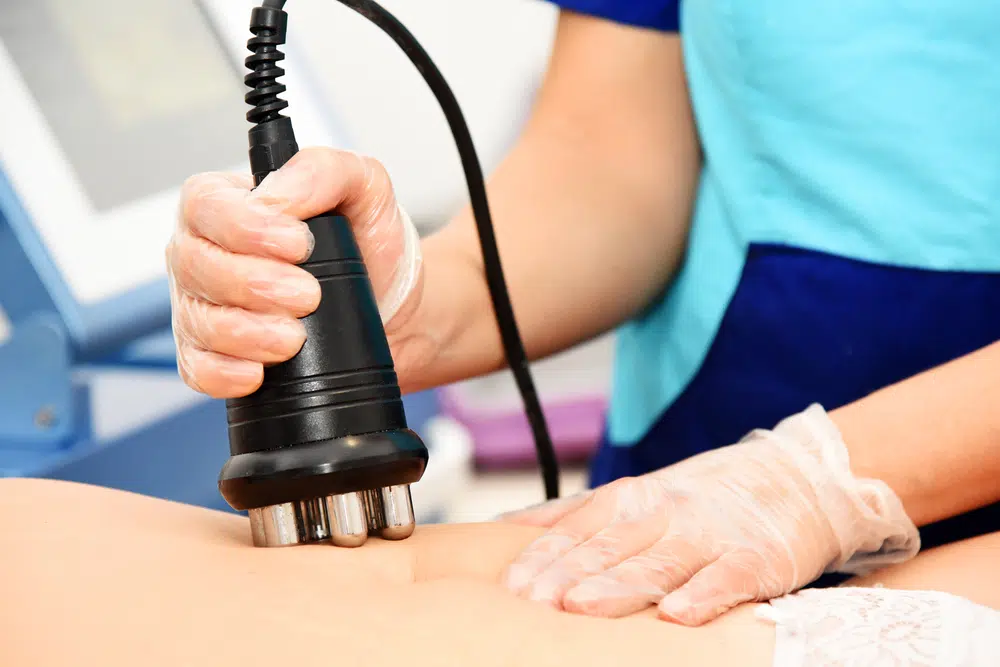 a photo of a woman getting body sculpting treatment on her stomach