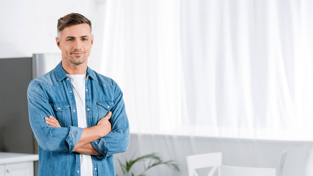 a photo of a man standing in a bedroom