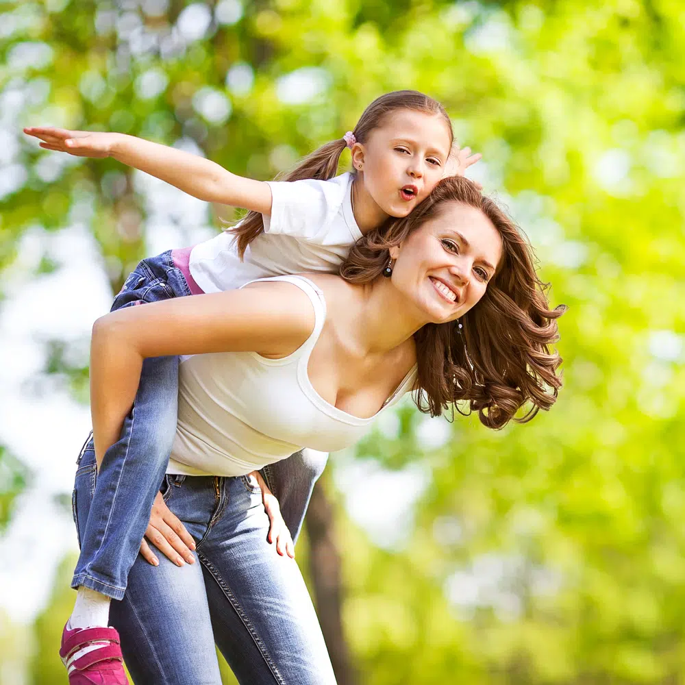 a photo of a mother giving her daughter a piggy back ride