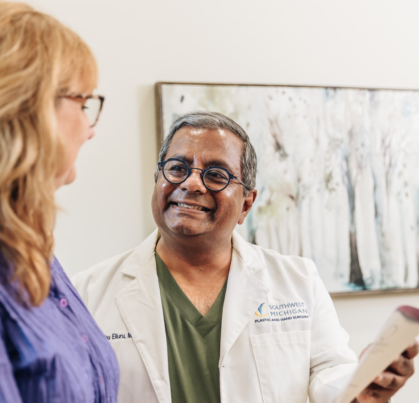 A doctor smiles as he performs a patient consultation for Skin Tightening in Portage