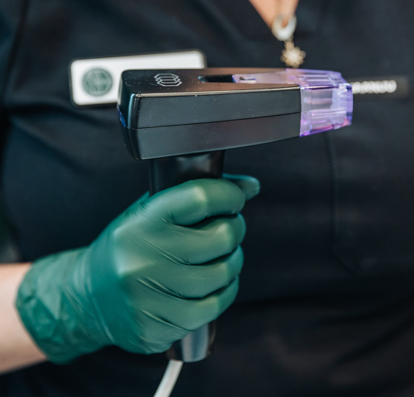 A woman in plastic gloves holds up an applicator for Morpheus in Kalamazoo County
