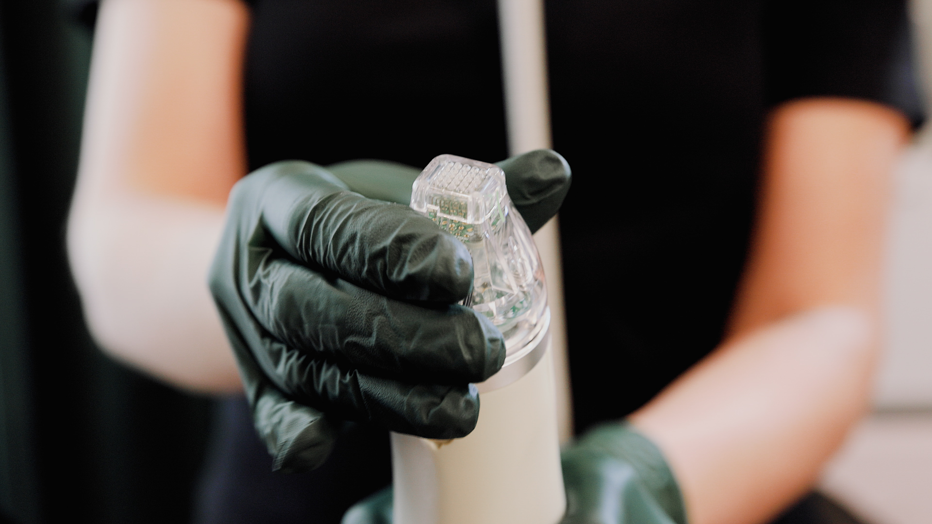 A provider wearing black gloves prepares a microneedling device at our skin care clinic near Kalamazoo.