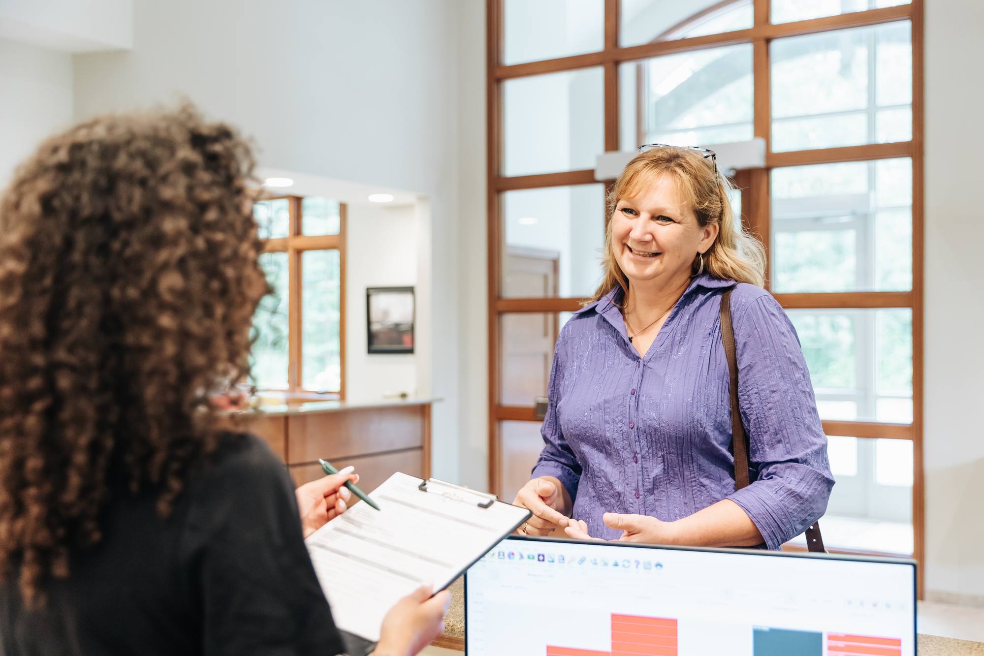 A patient laughs while checking in for one of our chemical peels near Kalamazoo.